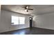 Spacious and bright living area with sleek flooring, a ceiling fan, and a large window at 9 Pine Radial Ct, Ocala, FL 34472
