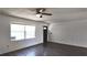 Bright living area featuring lovely flooring, a ceiling fan, and a large window at 9 Pine Radial Ct, Ocala, FL 34472