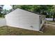 Side exterior showcasing the siding, white fence, and lawn at 9 Pine Radial Ct, Ocala, FL 34472