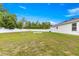 Expansive grassy backyard features a partial fence, providing privacy, and an outdoor area at 97 Dogwood Cir, Ocala, FL 34472