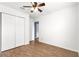 Bright bedroom with hardwood floors, ceiling fan, and a closet provides ample storage at 97 Dogwood Cir, Ocala, FL 34472