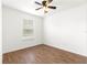 Minimalist bedroom with hardwood floors, a ceiling fan, and a window for natural light at 97 Dogwood Cir, Ocala, FL 34472