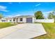 This house has a paved driveway, a grey roof and shutters, and a well-maintained lawn at 97 Dogwood Cir, Ocala, FL 34472