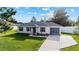 Charming single-story home with well-manicured lawn, gray shutters, and single car garage at 97 Dogwood Cir, Ocala, FL 34472