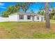Charming single-story home with a well-maintained lawn, a grey roof and shutters, and a paved driveway at 97 Dogwood Cir, Ocala, FL 34472