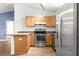 Well-lit kitchen with wooden cabinetry, stainless steel appliances, and wood-style floors at 97 Dogwood Cir, Ocala, FL 34472