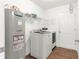 Bright laundry room with full-size washer, dryer, water heater, metal shelving, and wood-look floors at 97 Dogwood Cir, Ocala, FL 34472