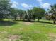 Large grassy backyard with scattered shade trees and a clear sky, ideal for outdoor activities at 9920 Sw 102Nd Pl, Ocala, FL 34481
