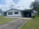 Classic single-story home featuring a covered parking area and an inviting front lawn at 9920 Sw 102Nd Pl, Ocala, FL 34481