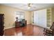 Bright bedroom with a hardwood floors, ceiling fan, desk and built-in shelving creating a versatile living space at 10347 Se 178Th Pl, Summerfield, FL 34491