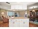 Bright open-concept kitchen island with seating, granite countertops, and custom cabinetry, flowing into living and dining areas at 10347 Se 178Th Pl, Summerfield, FL 34491