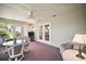 Enclosed sunroom with a ceiling fan, French doors, and comfortable wicker furniture at 10347 Se 178Th Pl, Summerfield, FL 34491