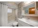 Charming bathroom with a tub, shower, and decorative wood-look accent wall around the mirror at 11091 Sw 76Th Ter, Ocala, FL 34476