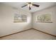 Bright and airy bedroom with two windows, tile flooring, and a ceiling fan ensuring comfort at 11091 Sw 76Th Ter, Ocala, FL 34476