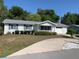 Well-kept home featuring a manicured lawn, a paved driveway, and an attached garage at 11445 Sw 84Th Avenue Rd, Ocala, FL 34481