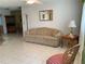 Bright and airy living room featuring a sofa, side table, and tiled flooring at 11445 Sw 84Th Avenue Rd, Ocala, FL 34481