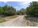 Long, paved driveway leading to a secluded home surrounded by lush greenery and mature trees at 11447 Sw 128Th Ave, Dunnellon, FL 34432