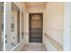 Covered front porch features neutral tile flooring and a secure screened front door at 11447 Sw 128Th Ave, Dunnellon, FL 34432