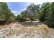 Expansive front yard with mature trees and a charming wooden fence, located on a tranquil lot at 11447 Sw 128Th Ave, Dunnellon, FL 34432