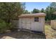 Small shed featuring double doors and a window providing natural light, set amidst green surroundings at 11447 Sw 128Th Ave, Dunnellon, FL 34432