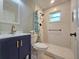 Modern bathroom with white tile, walk-in shower, grab bar, and stylish vanity at 116 Nw 17Th Pl, Ocala, FL 34475