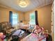 Cozy Bedroom featuring a crib, rocking horse, and ample natural light from two windows at 116 Nw 17Th Pl, Ocala, FL 34475