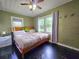 Spacious bedroom featuring a ceiling fan, hardwood floors, and natural light from the windows at 116 Nw 17Th Pl, Ocala, FL 34475