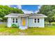 Charming single-story home with light blue paint, a yellow front door, and a well-maintained front yard at 116 Nw 17Th Pl, Ocala, FL 34475