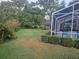 Spacious backyard featuring lush green grass, screened-in lanai, and mature trees for privacy at 11651 Sw 77Th Cir, Ocala, FL 34476