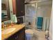 Bathroom showcasing a tiled shower, granite countertop, and vanity with dark wood cabinets at 11651 Sw 77Th Cir, Ocala, FL 34476