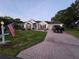 Charming home with brick driveway, American flag, and well-maintained lawn at 11651 Sw 77Th Cir, Ocala, FL 34476