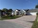 Attractive home showcasing a brick driveway and well-manicured lawn at 11651 Sw 77Th Cir, Ocala, FL 34476