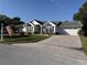 Charming single-story home featuring an attached two-car garage and a well manicured lawn at 11651 Sw 77Th Cir, Ocala, FL 34476