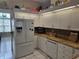 Efficient kitchen features white appliances, granite counters, and ample cabinet space at 11651 Sw 77Th Cir, Ocala, FL 34476