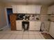 Functional laundry room with ample storage cabinets, a desk area, and tiled floors at 11651 Sw 77Th Cir, Ocala, FL 34476