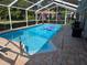 Screened-in in-ground pool with ladder for easy access, and pavers surrounding at 11651 Sw 77Th Cir, Ocala, FL 34476