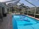 A screened-in in-ground pool area with patio furniture provides a relaxing backyard retreat at 11651 Sw 77Th Cir, Ocala, FL 34476
