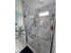 Bathroom featuring a shower with marble-look tile and a seamless glass door at 11651 Sw 77Th Cir, Ocala, FL 34476