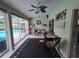 Bright sunroom with tiled floor and windows overlooking pool, featuring a ceiling fan and comfortable seating at 11651 Sw 77Th Cir, Ocala, FL 34476
