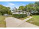 Single-story home with long driveway, green lawn, and privacy hedges at 13102 Se 101St Ave, Belleview, FL 34420