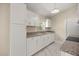 A bright kitchen featuring white cabinetry, granite countertops, and stainless steel appliances at 13102 Se 101St Ave, Belleview, FL 34420