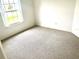 Neutral bedroom featuring carpet flooring, white walls, and a bright window at 1402 Arredondo Dr, The Villages, FL 32162