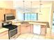 Kitchen with breakfast bar, stainless steel appliances, and a seamless view of the light-filled living space at 1402 Arredondo Dr, The Villages, FL 32162