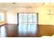 Living room featuring hardwood floors, vaulted ceilings, fan, and large sliding glass doors to the lanai at 1402 Arredondo Dr, The Villages, FL 32162