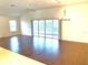 Spacious living area featuring hardwood floors, ceiling fan, vaulted ceilings, and sliding door access to the lanai at 1402 Arredondo Dr, The Villages, FL 32162