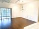 Spacious living area featuring hardwood floors, ceiling fan, vaulted ceilings, and sliding door access to the lanai at 1402 Arredondo Dr, The Villages, FL 32162