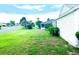 Side yard featuring a manicured lawn and partial home view at 1402 Arredondo Dr, The Villages, FL 32162