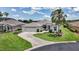 Beautifully landscaped home featuring a curved driveway, palm trees, and attached garage at 1427 Sw 161St St, Ocala, FL 34473