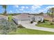 Charming home with a two-car garage, well-manicured lawn, and lush landscaping with a palm tree at 1427 Sw 161St St, Ocala, FL 34473