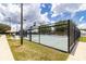 Fenced tennis and basketball court with multiple nets and lighting for year-round play at 1427 Sw 161St St, Ocala, FL 34473